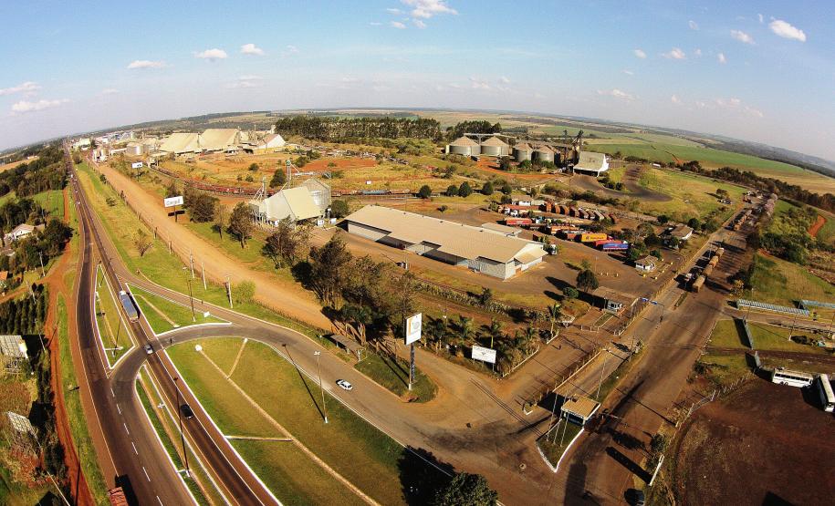 Entrada da Ferroeste com vista aérea de silos e moega, ao fundo.